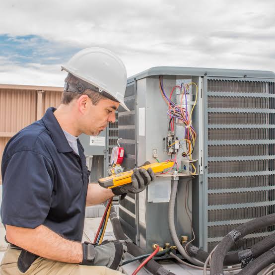 HVAC technician diagnosing an outdoor air conditioning unit