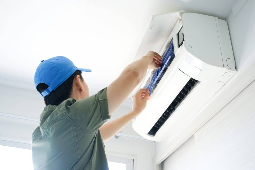 Technician performing maintenance on a wall-mounted mini-split system